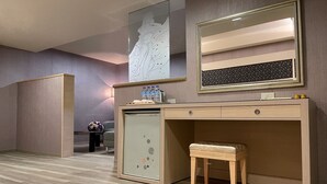 A modern room with a wooden desk, a small stool, a wall-mounted mirror, and a decorative wall piece. - Beidoo Hotel (Keelung)