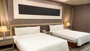A hotel room with two beds, a large framed artwork above the beds, and a wooden headboard. - Beidoo Hotel (Keelung)