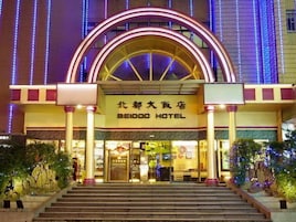 Exterior del Hotel Beidoo con una entrada destacada, un gran arco y un cartel en chino e inglés.