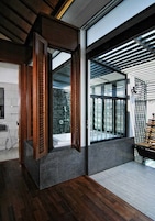 Un baño moderno con tocador de madera, cabina de ducha de vidrio y vistas al exterior.