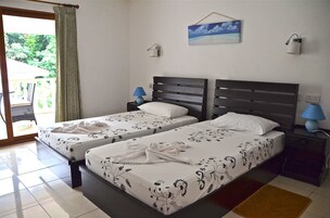 Habitación de hotel con dos camas, un balcón y un cuadro en la pared.