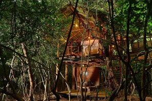 A rustic treehouse with a brick base and wooden upper levels, surrounded by dense forest. - Back of Beyond - Pidurangala (Sigiriya)