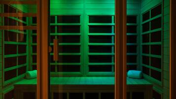 A room with a wooden bench, a small table, and a window with a view of the outside.