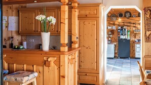 A wooden kitchen with cabinets, a countertop, and a vase with flowers.