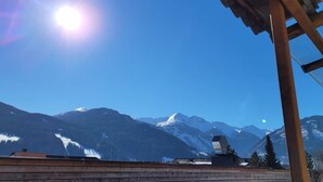 A wooden structure with a view of snow-capped mountains and a clear sky.