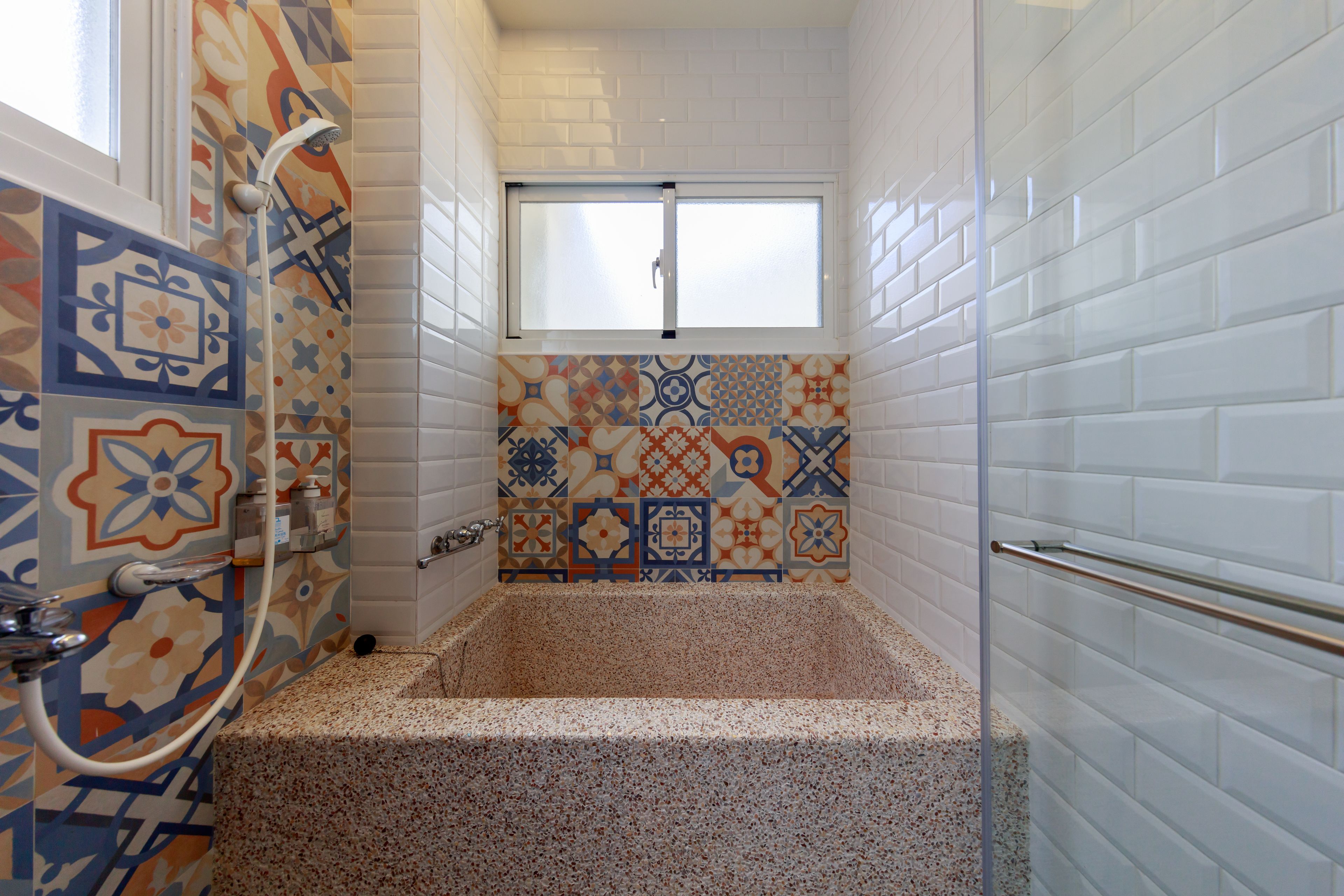 Un bagno con una vasca, una doccia e una finestra.