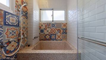 Un bagno con una vasca, una doccia e una finestra.