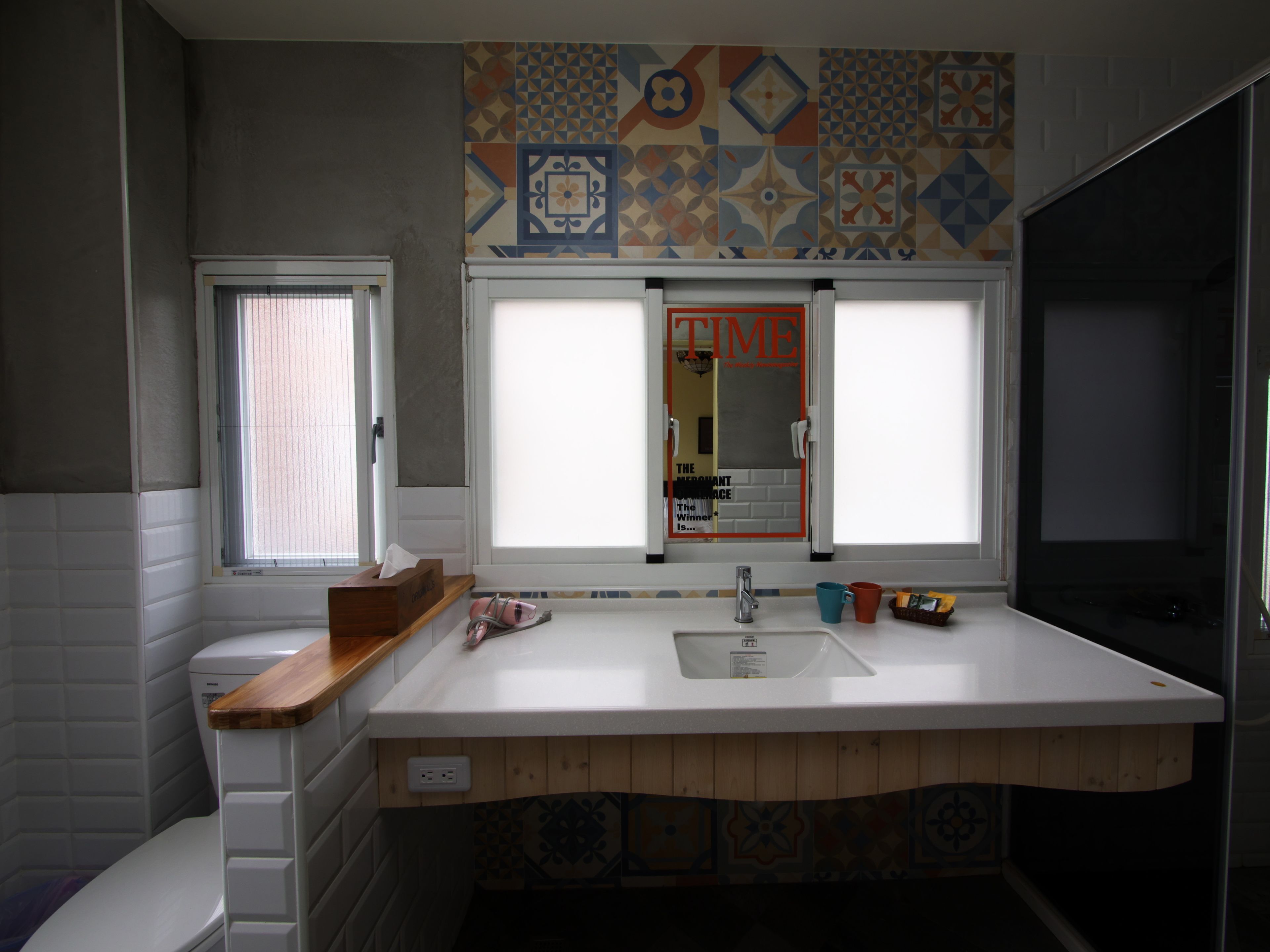 A bathroom with a wooden vanity, a sink, and a mirror.