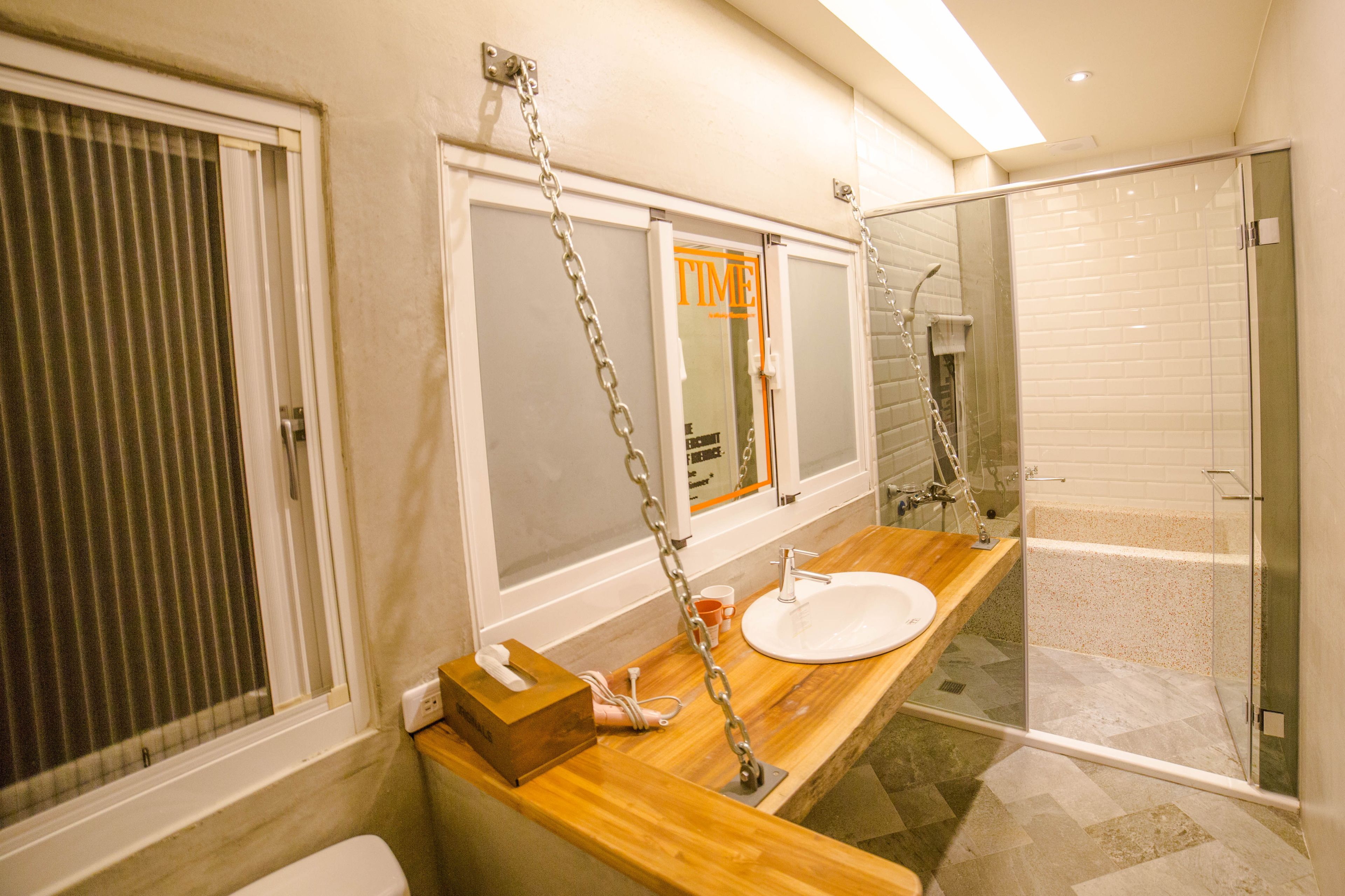 A modern bathroom with a wooden vanity, a glass shower enclosure, and a toilet.