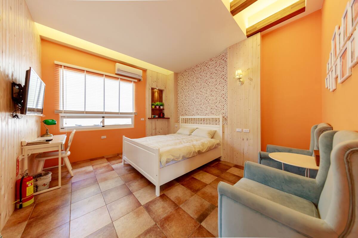 Un dormitorio con cama, escritorio y silla.