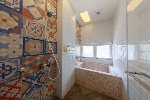 A bathroom with a freestanding bathtub, a showerhead, and a window. - Oia Cafe B&B (Taitung)