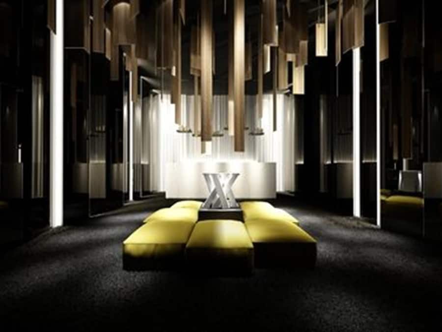 A modern hotel lobby with a central seating area, large windows, and a minimalist design.