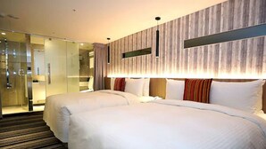 Une chambre d’hôtel avec deux lits, une douche en verre et un mur d’accent en bois.