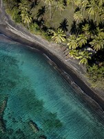 Playa privada, arena negra, toallas de playa, masajes en la playa