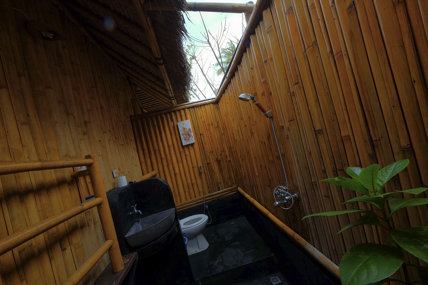Un baño pequeño de madera con inodoro, lavabo y ducha.