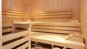 Una sauna con bancos de madera y bancos adosados.