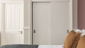 A bedroom with a bed, two doors, and a wall with a textured finish. - SACO Bristol- West India House (Bristol)