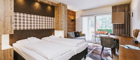 Una habitación de hotel moderna con una cama grande, un escritorio y vistas al exterior.