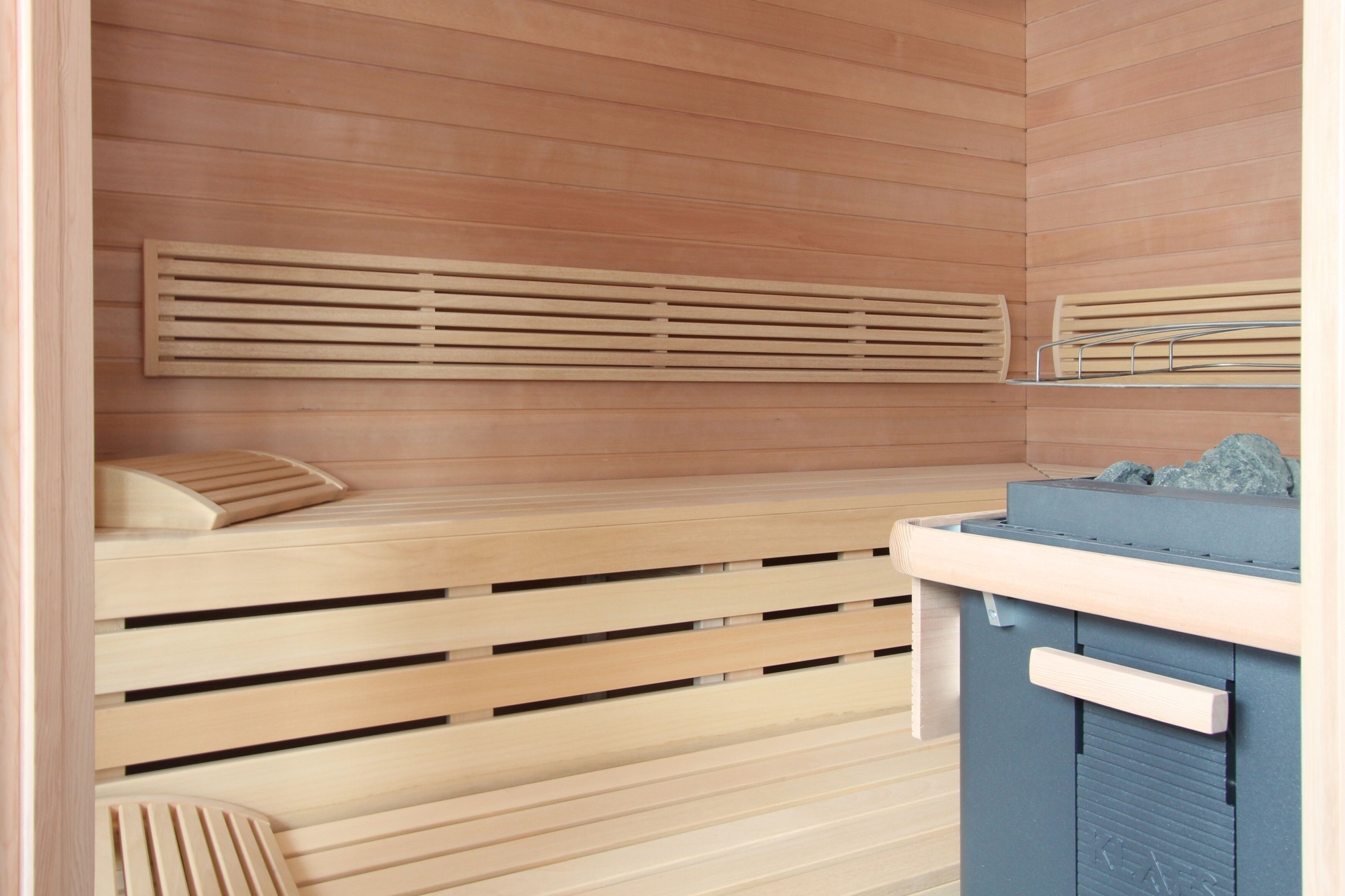Una sauna con bancos de madera y un armario azul.