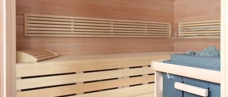 Una sauna con bancos de madera y un armario azul.