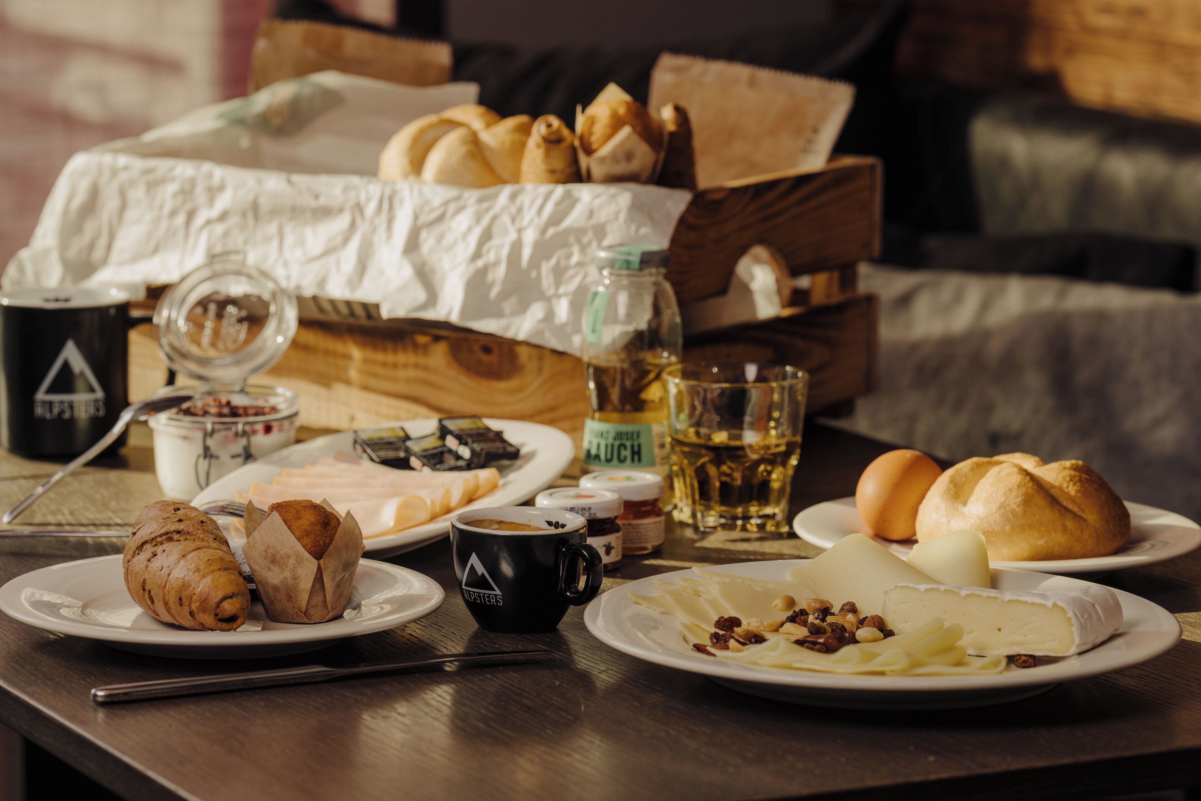 Ett frukostbord med croissanter, ost och en kaffekopp.