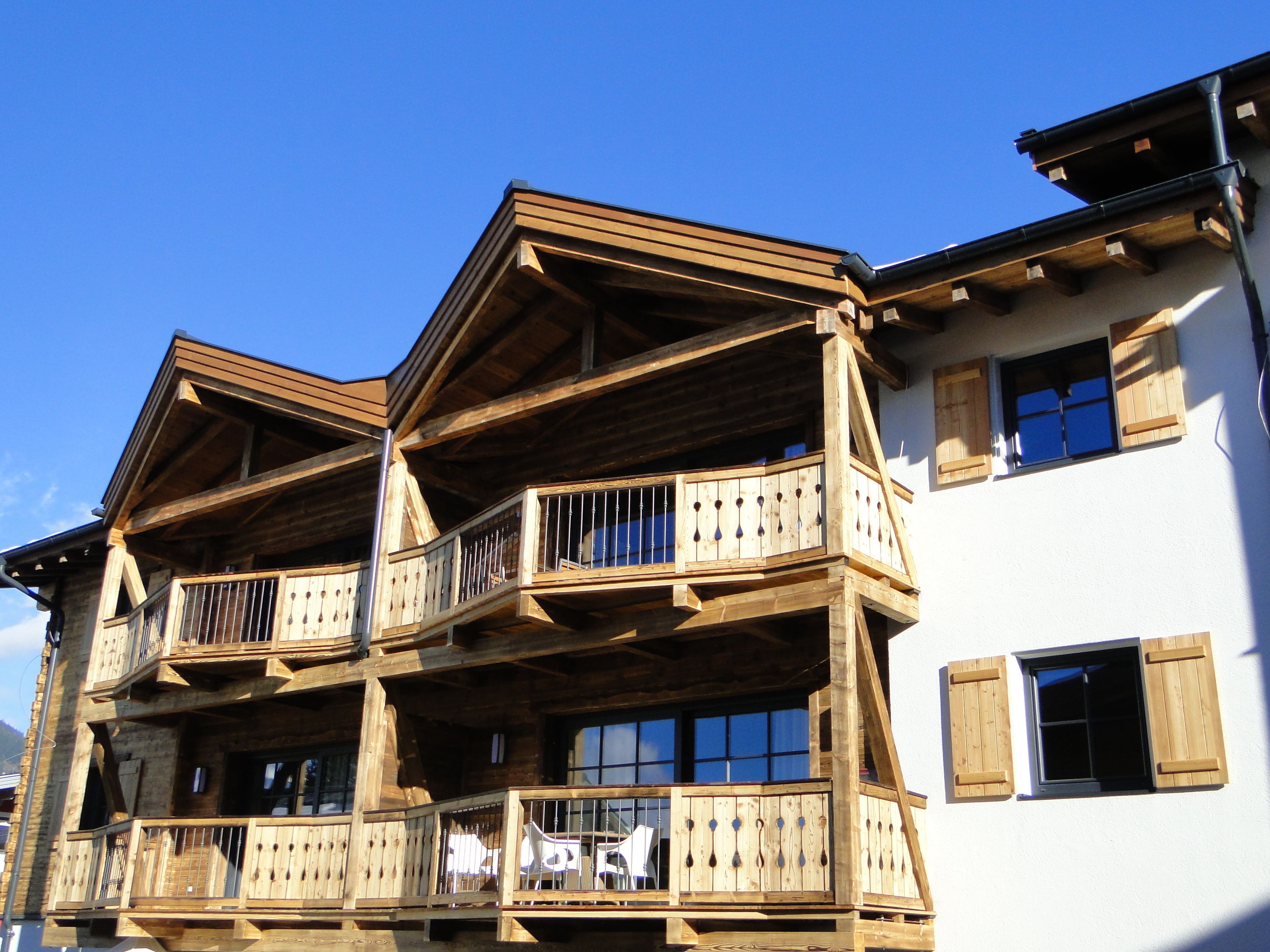 Un immeuble en bois à plusieurs étages, doté de balcons et de grandes fenêtres.