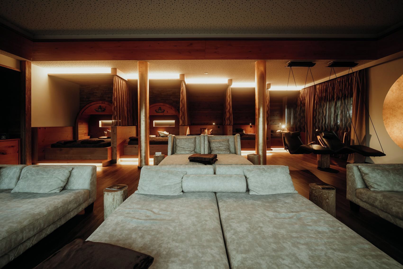 A modern interior with a large sofa, a chair, and a bed.