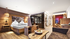Een moderne hotelkamer met een houten bed, een eethoek en een gezellige zithoek.