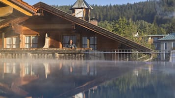 Situated on a wooden deck, this cabin offers a tranquil view of the surrounding forest and lake.