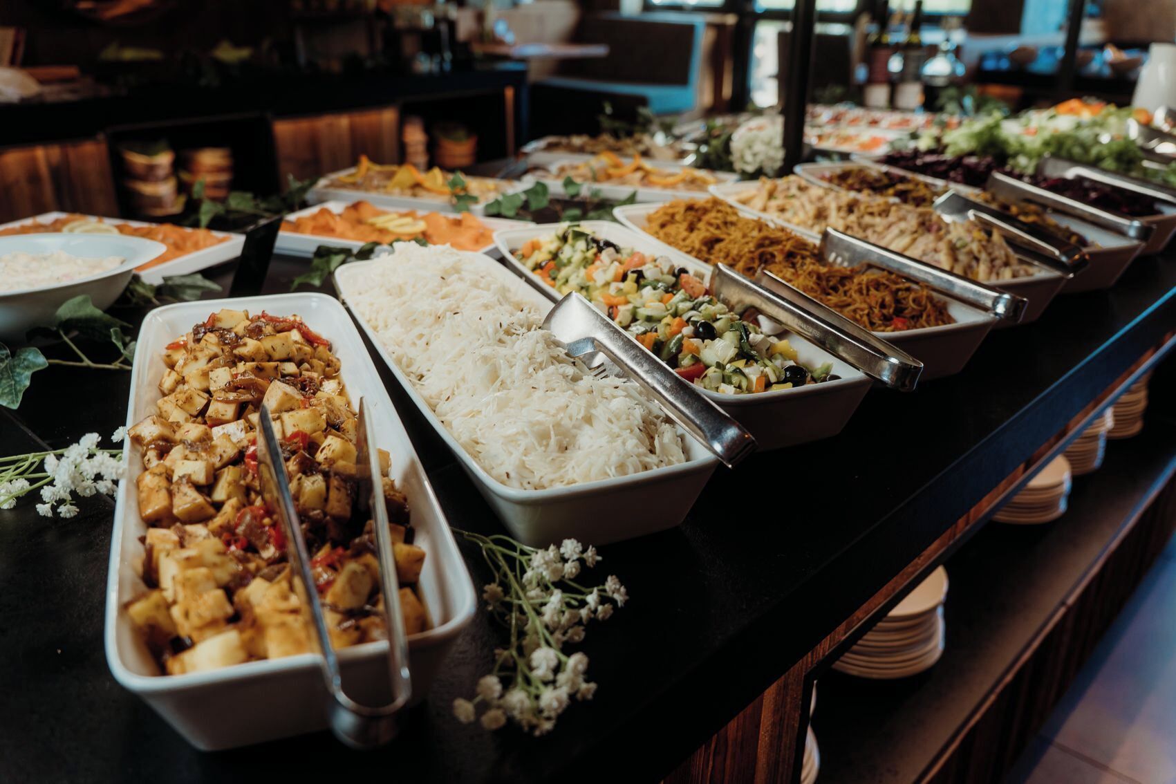 Ein Buffet mit verschiedenen Speisen, darunter Reis, Gemüse und Fleisch.