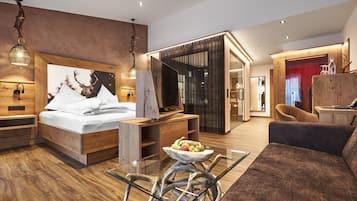 Una habitación de hotel moderna con una cama de madera, una mesa de centro de vidrio y un sofá.
