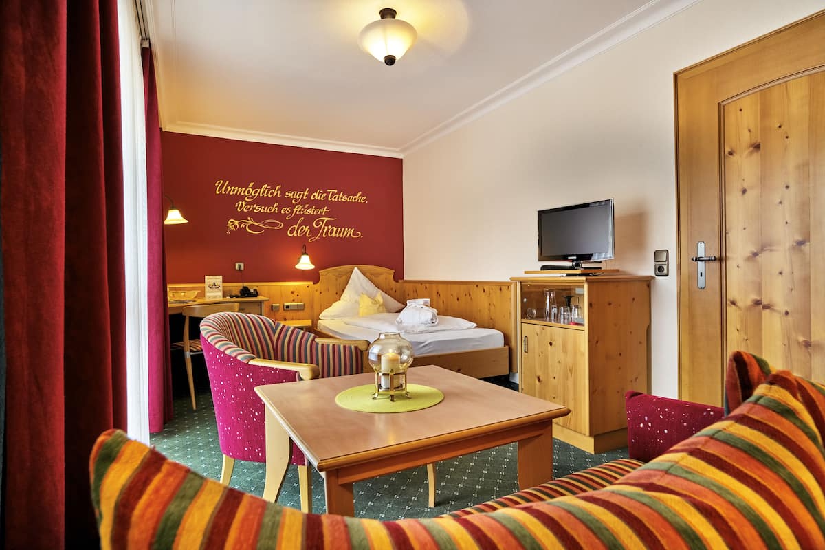 Une chambre d’hôtel confortable, équipée d’un lit, d’une télévision, d’un bureau et d’une chaise.