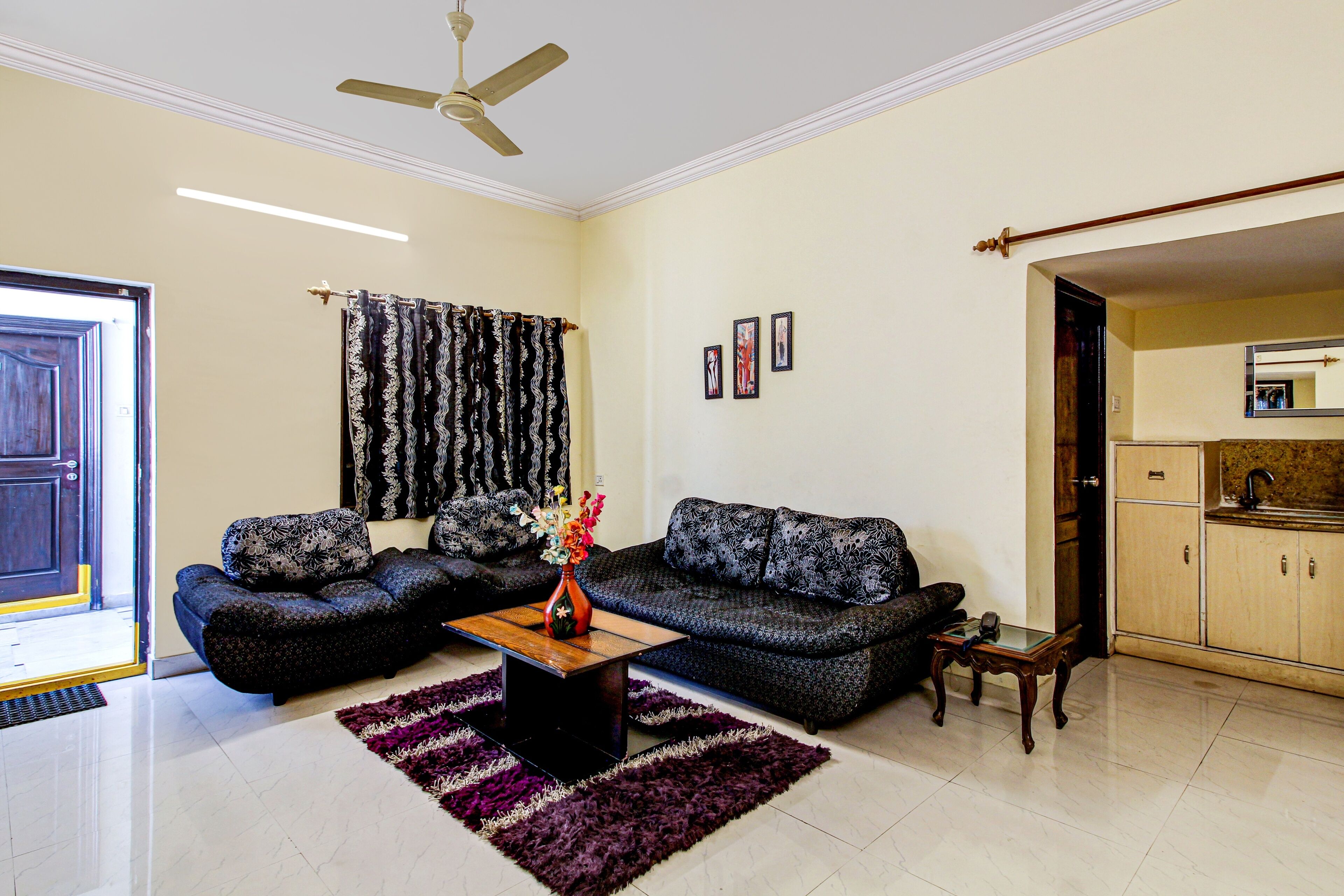 A living room with a sofa set, a coffee table, a rug, and a ceiling fan.