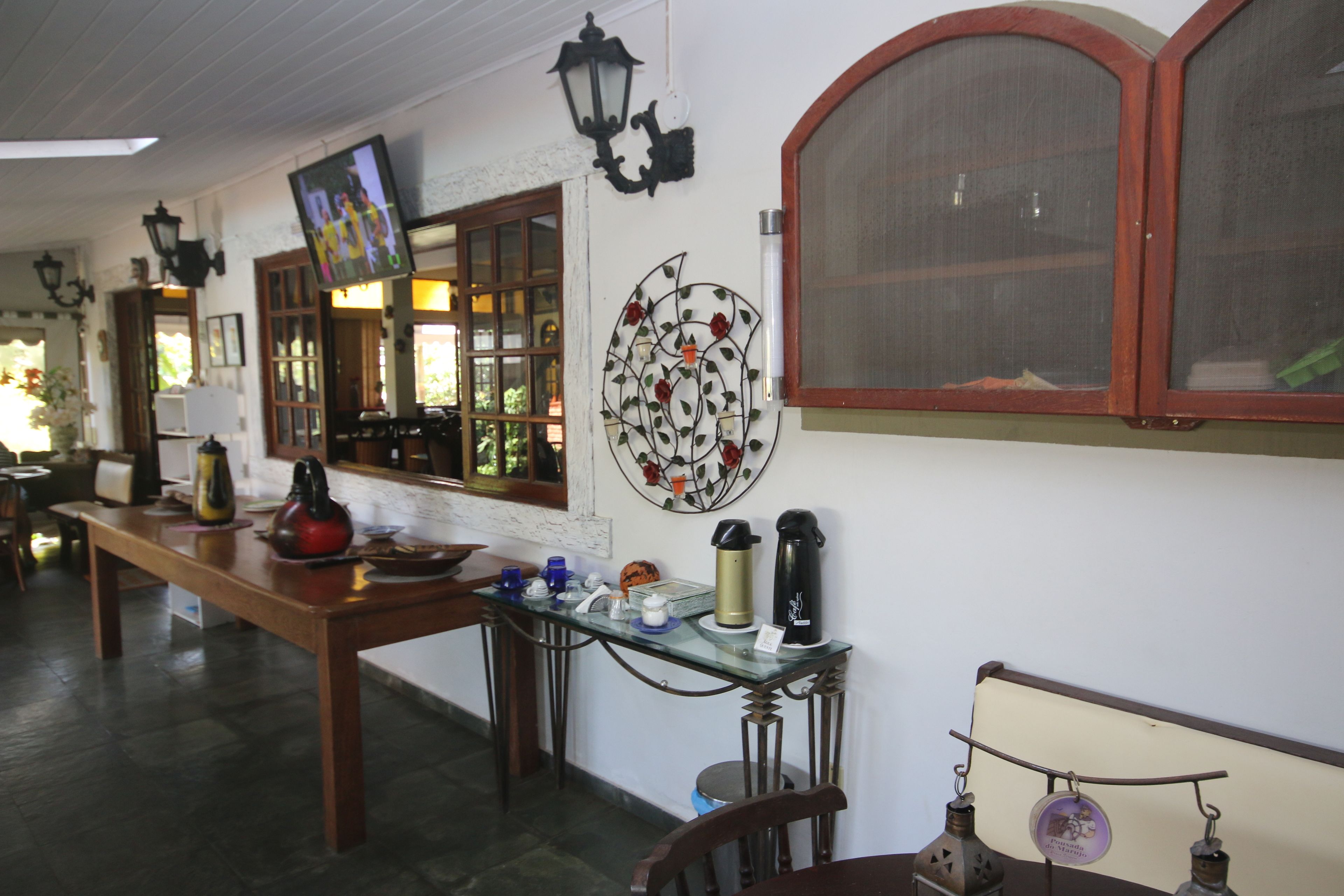 Una habitación acogedora con una mesa de madera, una mesita de centro de vidrio y un adorno en la pared.