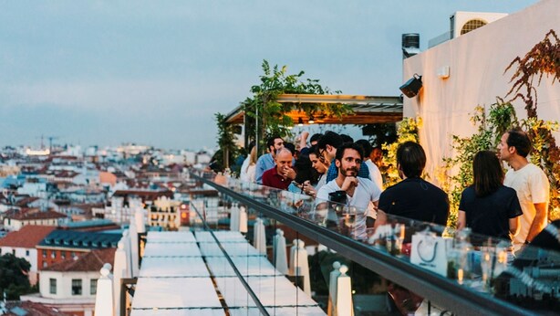 A rooftop bar with a city view, outdoor seating, and a glass railing. - Dear Hotel Madrid (Madrid)