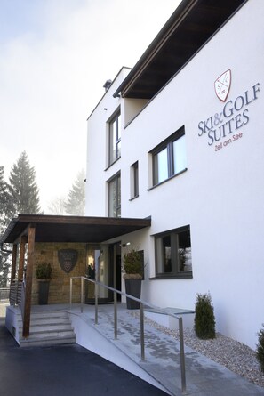 A modern building with a sign for "Ski & Golf Suites" and a stone entrance. - Ski & Golf Suites by Alpin Rentals - incl Summercard (Zell am See)