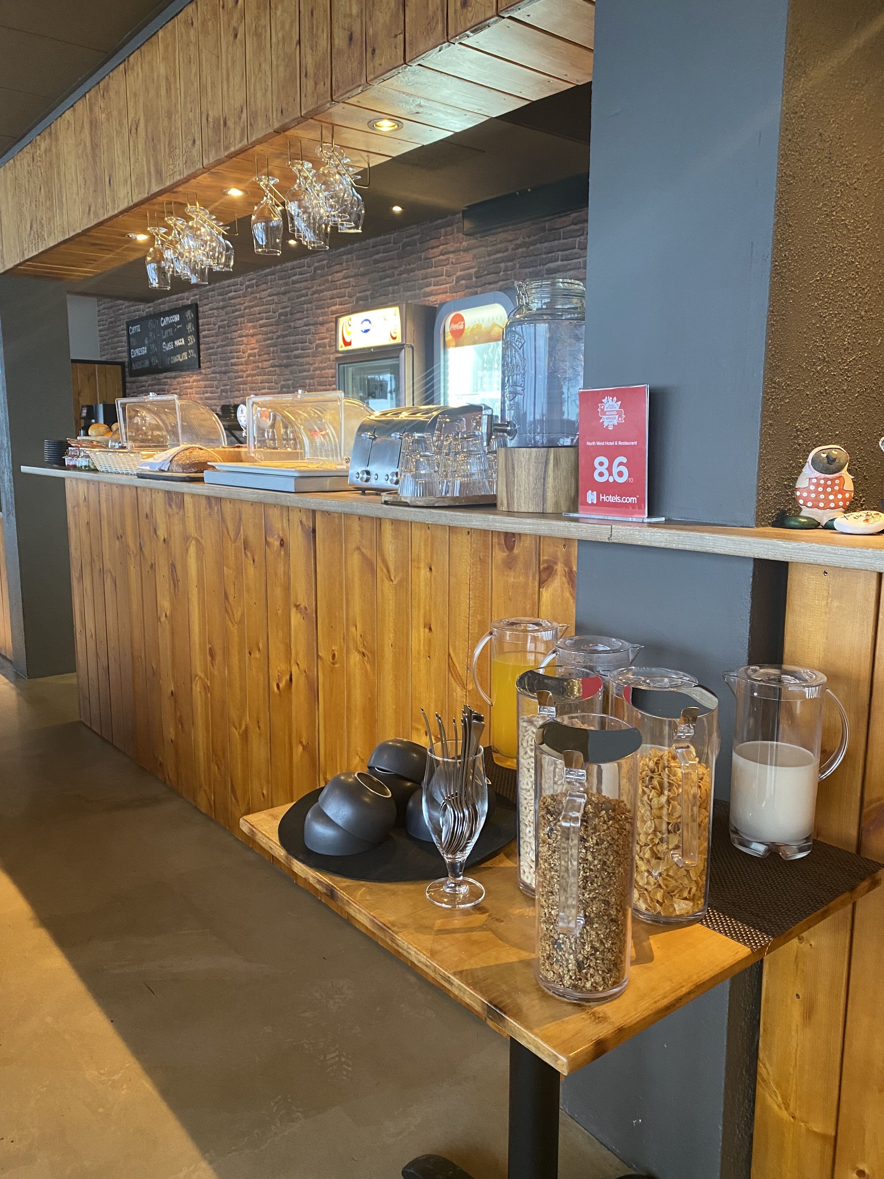 A coffee bar with a wooden counter, espresso machines, and a menu board.