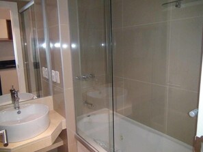 A modern bathroom with a glass-enclosed shower, a white sink, and a bathtub. - Green Park Punta 2 (Punta Ballena)