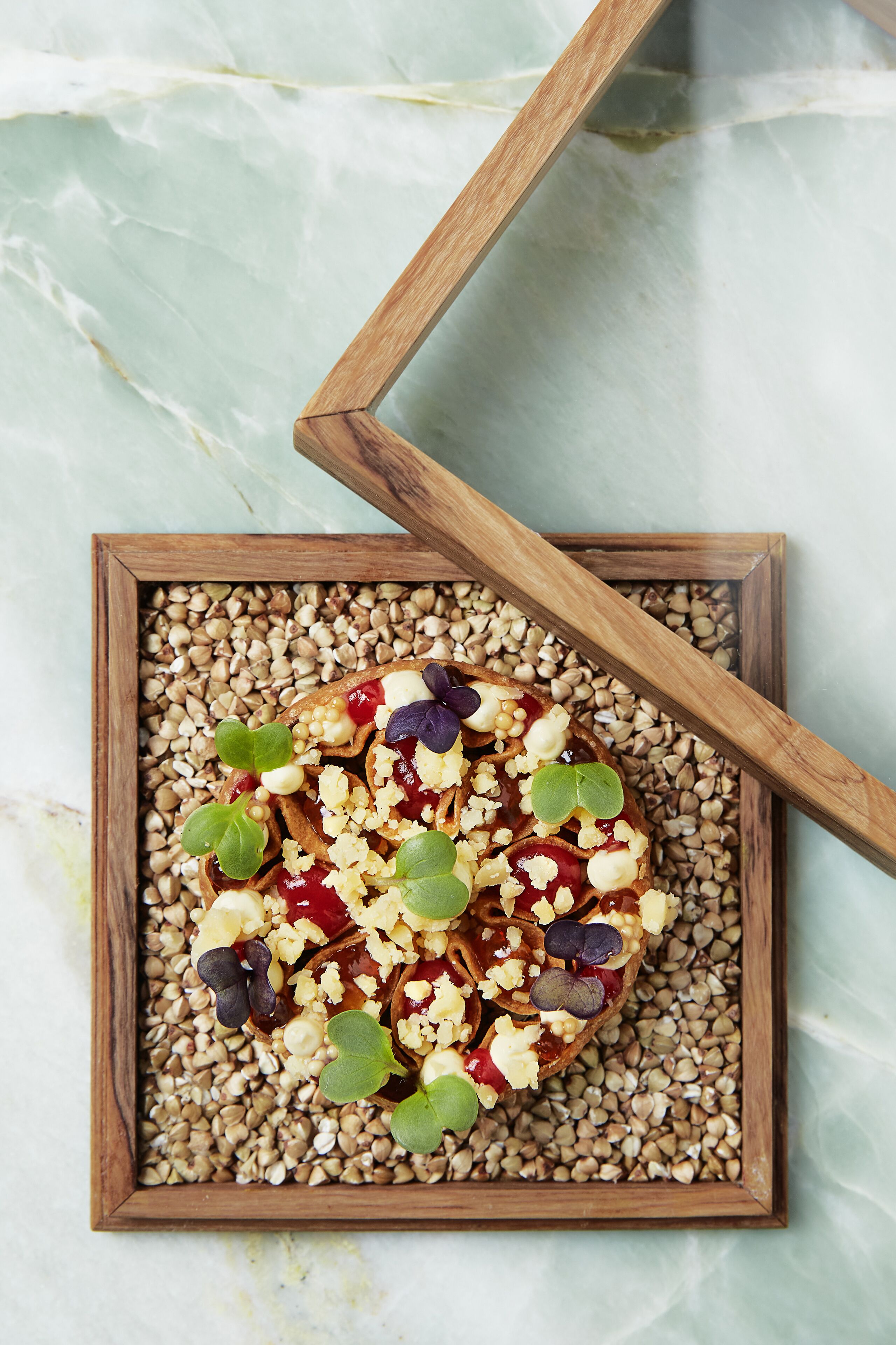 A wooden tray with a food item on a marble surface.