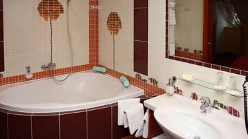 A bathroom with a bathtub, a sink, and a mirror.