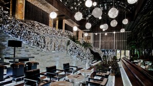 A modern interior with a curved staircase, seating areas, and hanging spherical lights. - Royal Castle Design & SPA Hotel (Elenite)