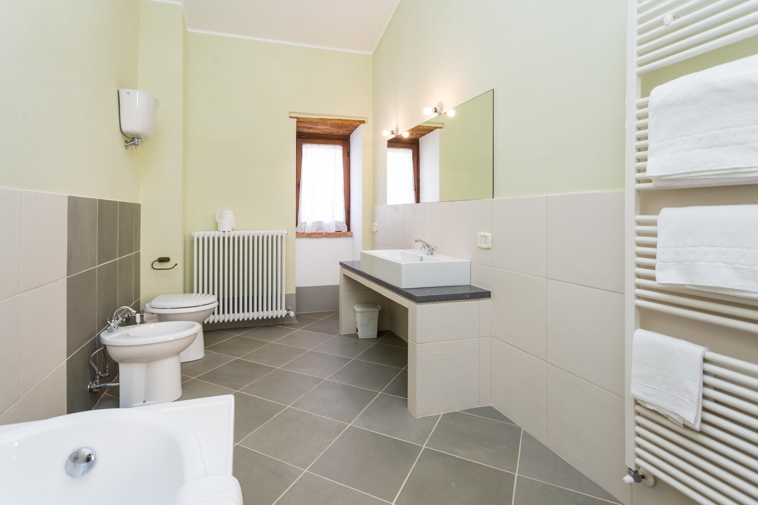 A modern bathroom with a bathtub, sink, and toilet.
