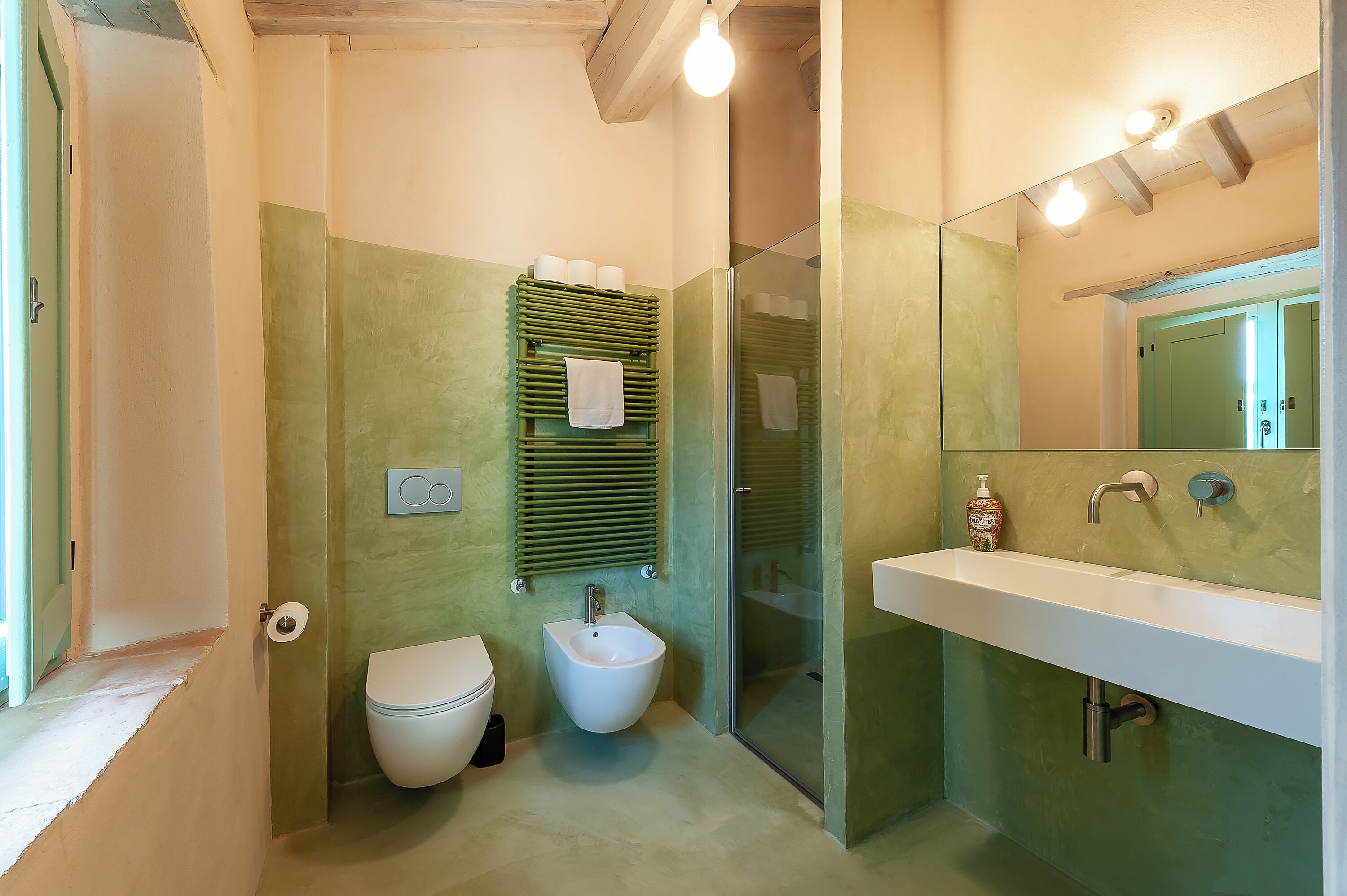 Un bagno con bidet, servizi igienici e lavandino.