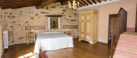 Un dormitorio con una cama de madera, una mesita de noche, un aparador y una escalera.