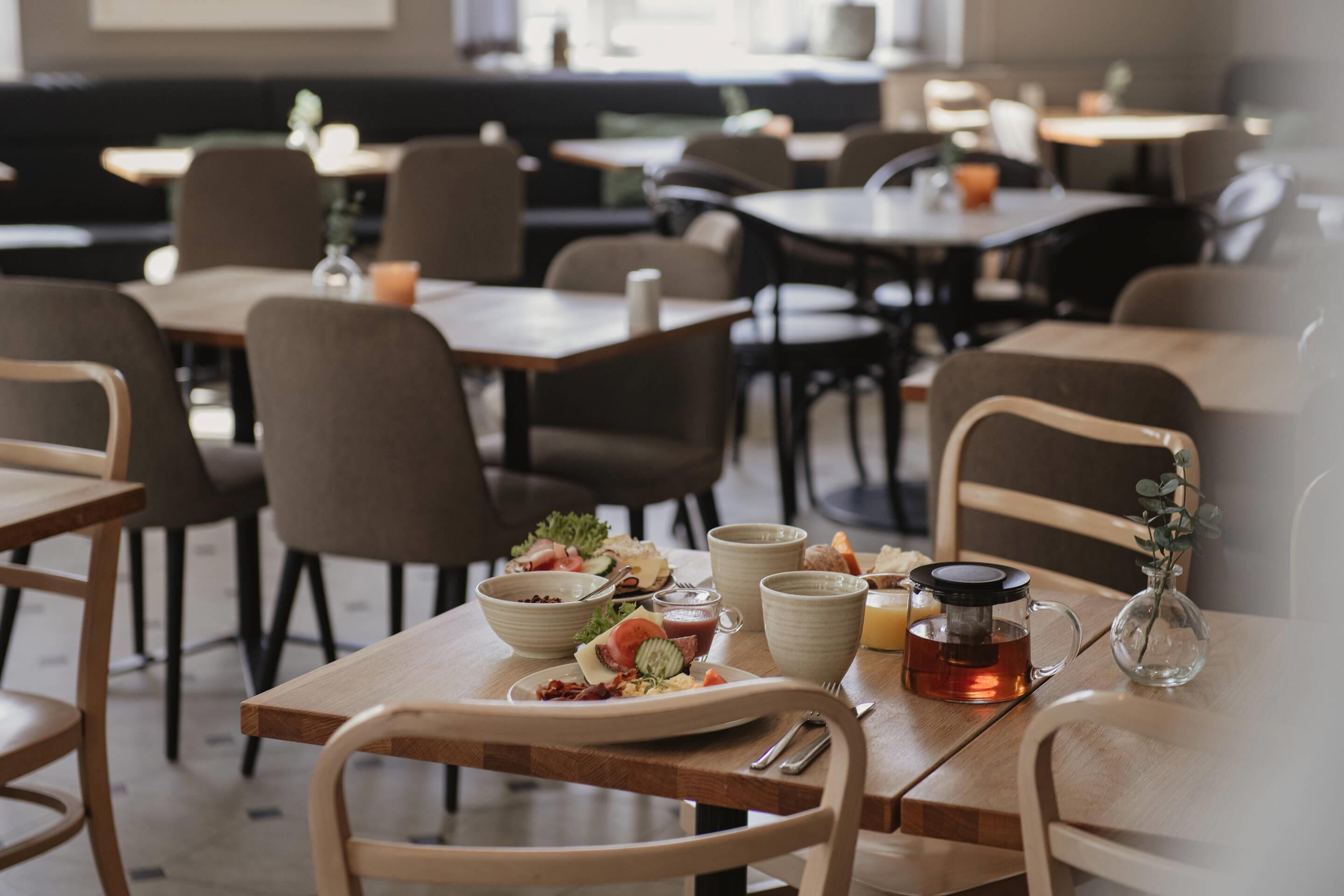 Een restaurantinterieur met tafels, stoelen en diverse gerechten.
