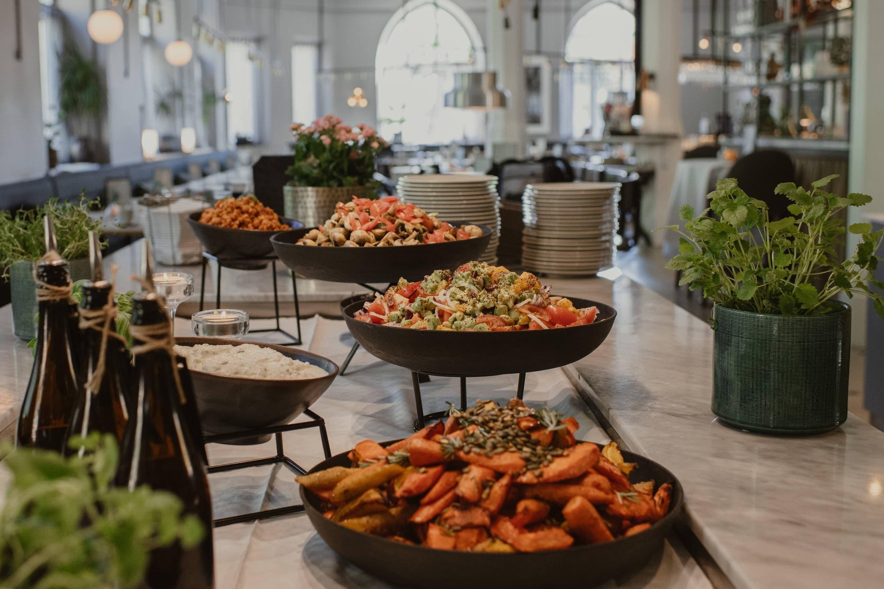 A buffet with various dishes, including salads, vegetables, and rice.