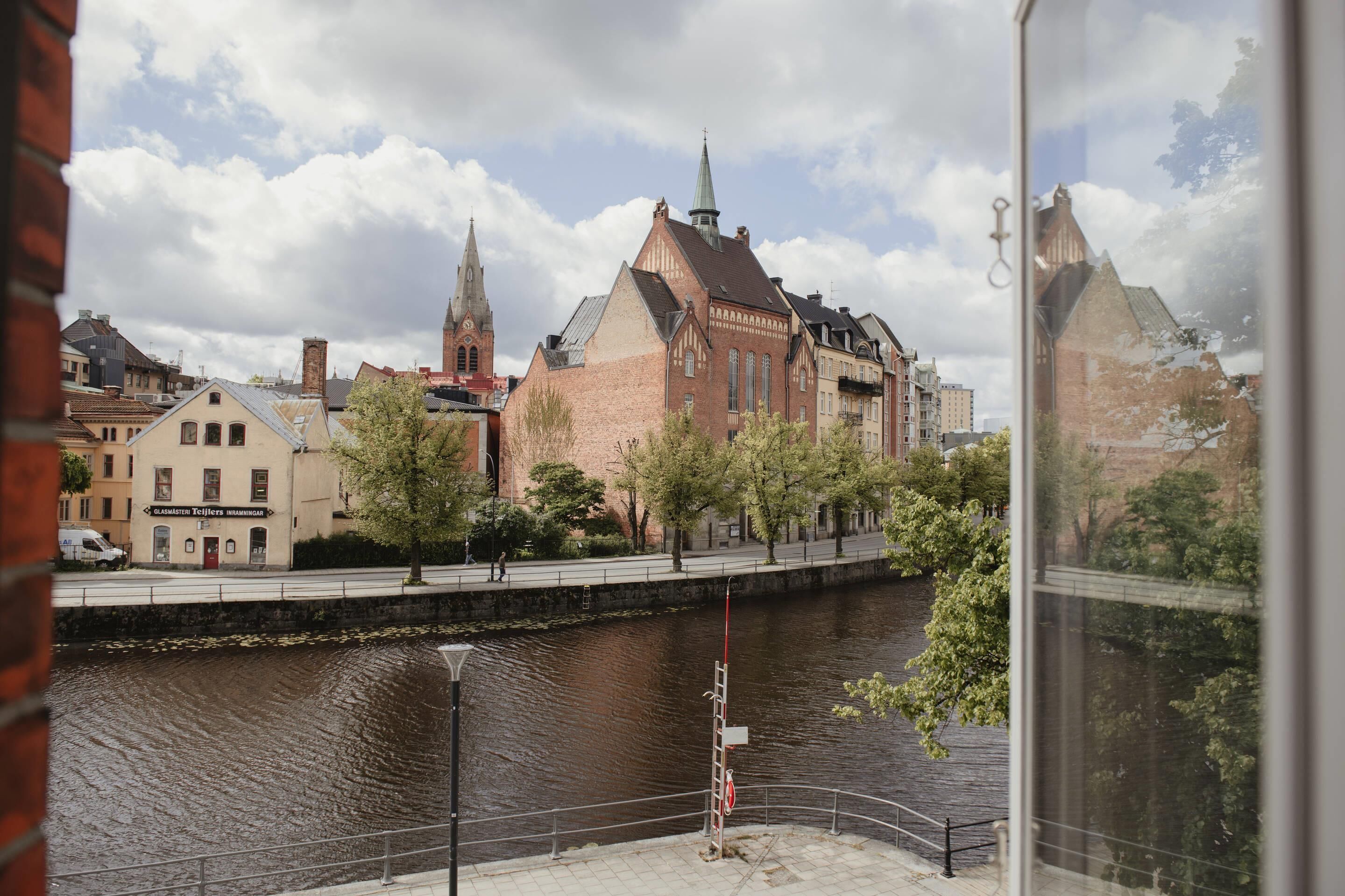 A riverside view with historic buildings, a bridge, and a lock system.