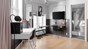 Een moderne keuken met een wit aanrecht, zwarte stoelen, een waterkoker en een waterkokertafel.