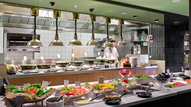 Een buffet met verschillende soorten eten en bestek.