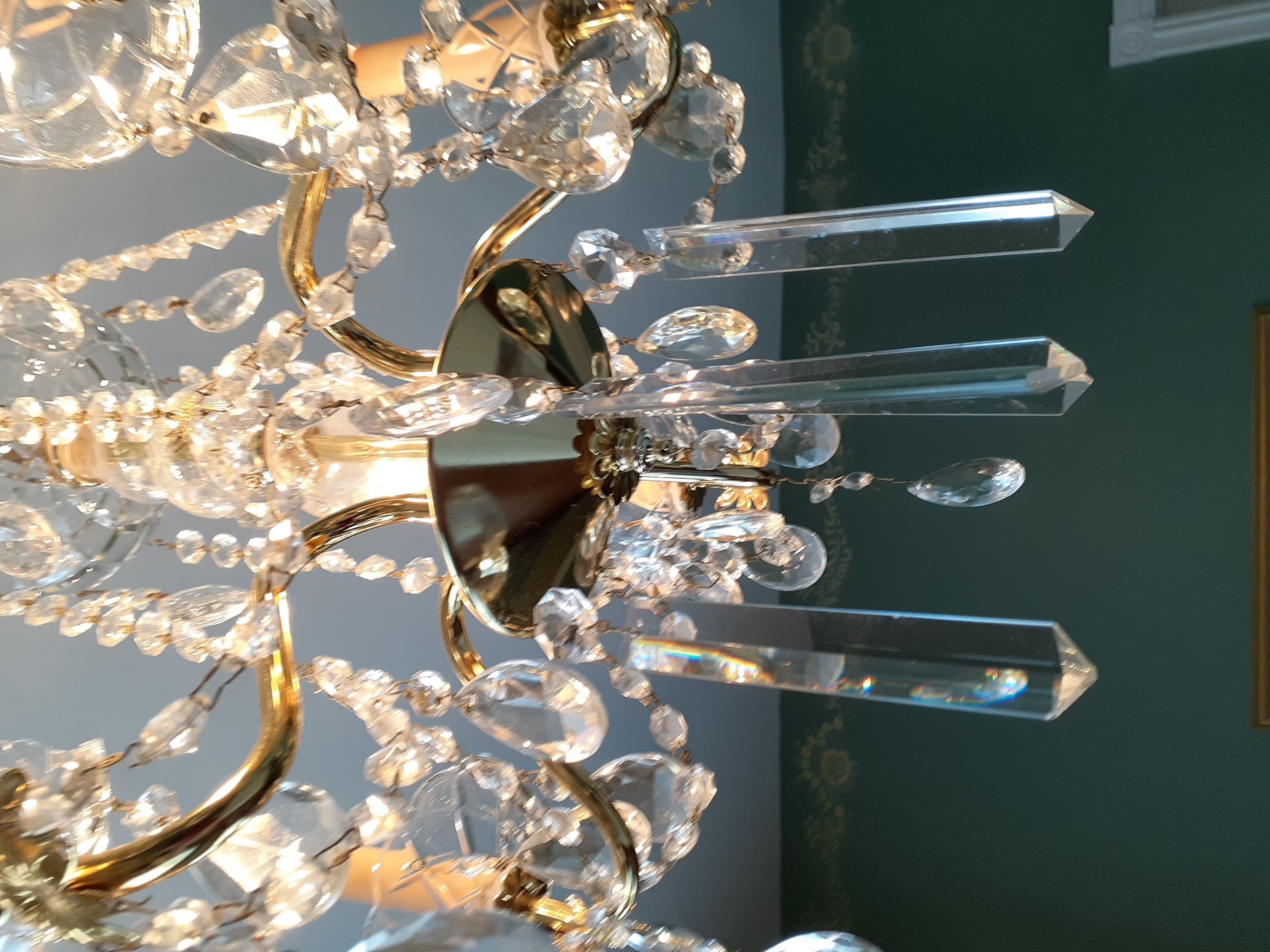 Un lustre composé de nombreux éléments de cristal et d’une pièce centrale réfléchissante.